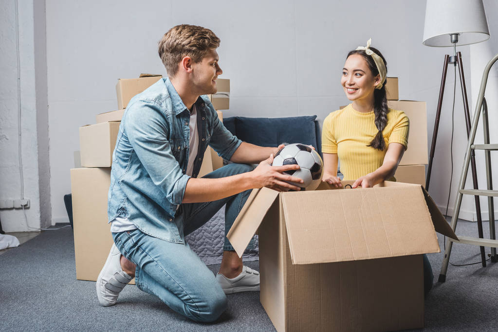 jovem casal desempacotando caixas enquanto se move para nova casa
 - Foto, Imagem