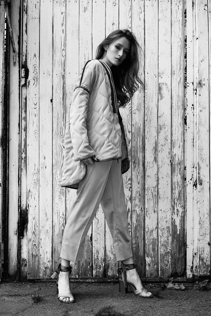 zwart / wit foto van stijlvolle jonge vrouw poseren buitenshuis - Foto, afbeelding