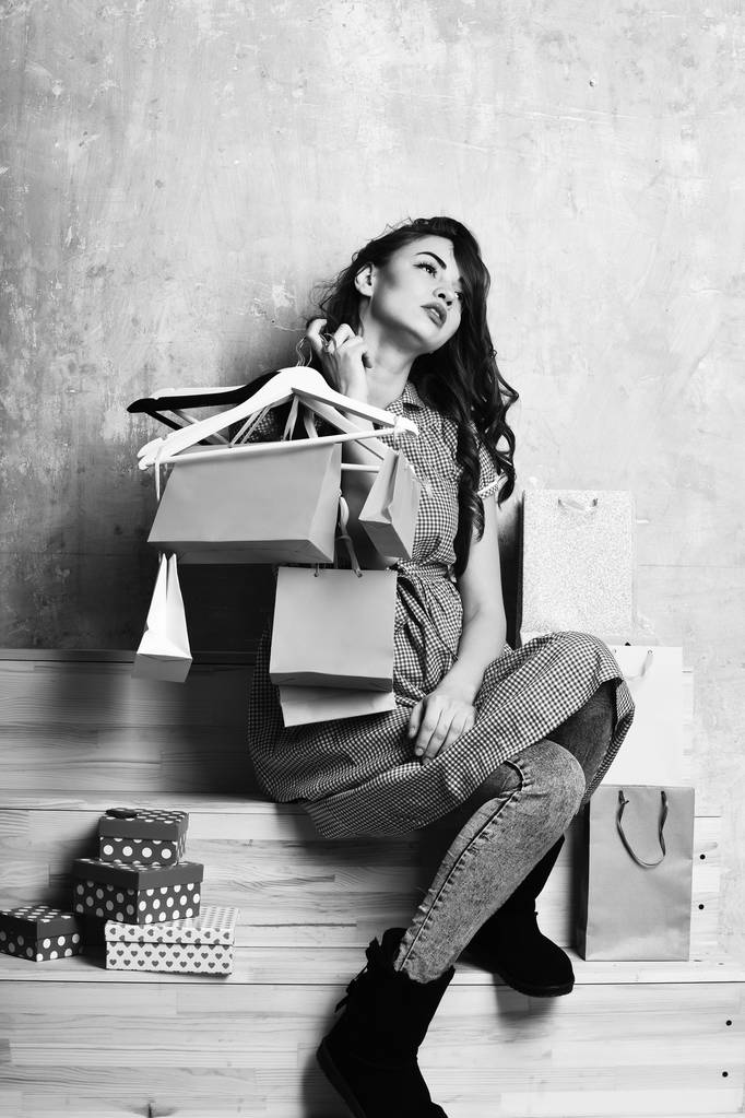 ziemlich sexy Frau mit Einkaufstaschen, Schachteln, Kleiderbügeln auf der Treppe - Foto, Bild