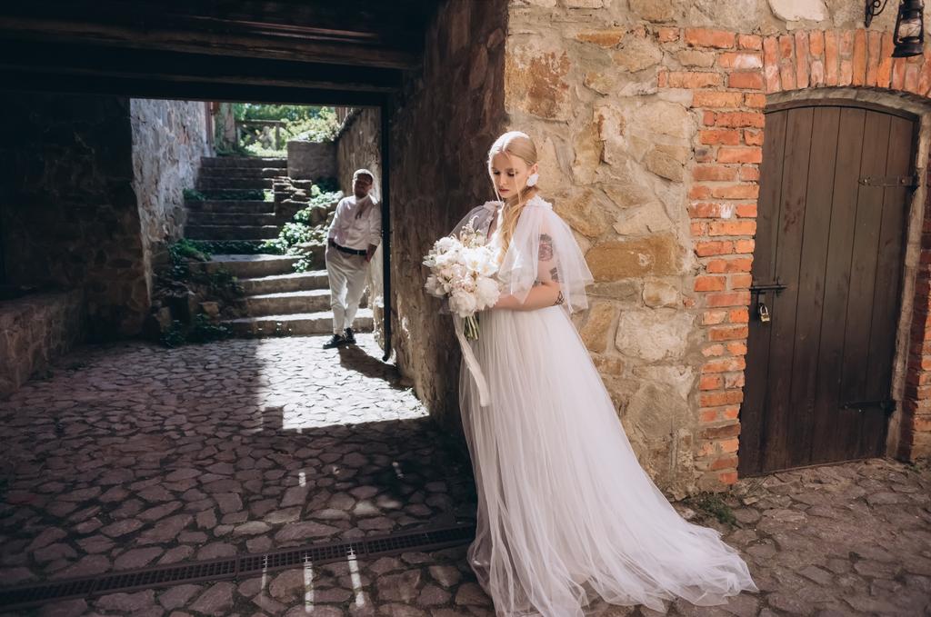 atraktivní mladá nevěsta a ženich pózuje ve starém městě - Fotografie, Obrázek