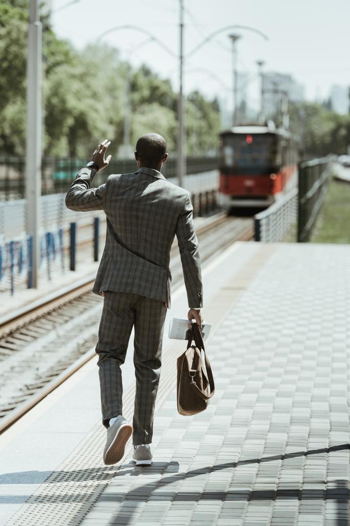 Empresário afro-americano vestindo terno esperando trem na estação
 - Foto, Imagem