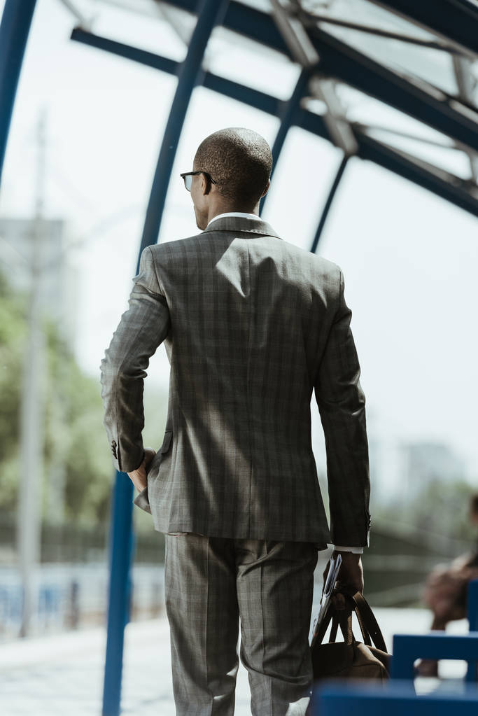 Hombre de negocios afroamericano con traje caminando en la estación de tren
 - Foto, imagen