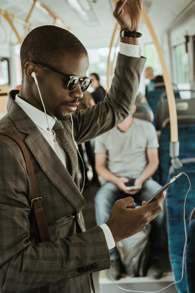 Elegante empresario confiado escuchando música mientras toma el tren
 - Foto, imagen