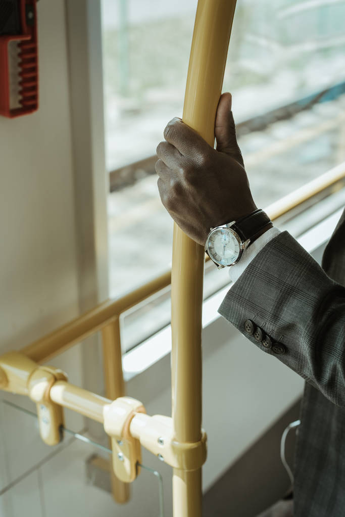 Περικοπεί θέα Αφρικανικός Αμερικανός επιχειρηματίας φοράει ρολόι ενώ παίρνετε το τρένο - Φωτογραφία, εικόνα