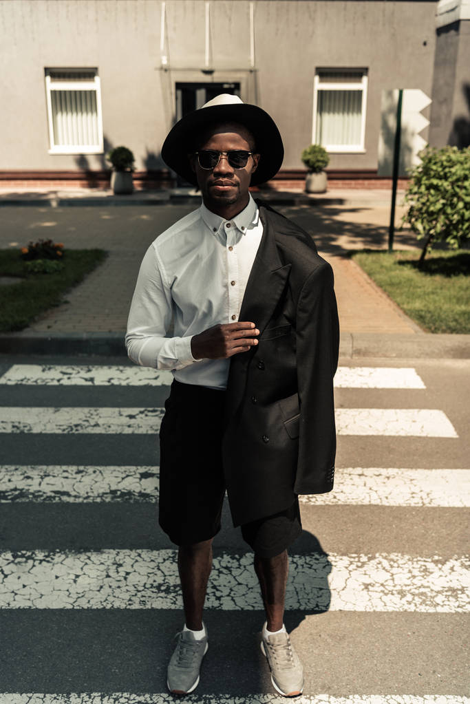 Guapo joven afroamericano llevando su chaqueta en el hombro
 - Foto, Imagen