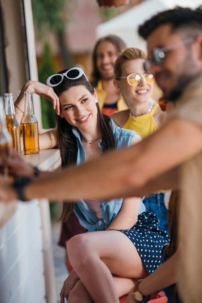 enfoque selectivo de los jóvenes felices bebiendo cerveza en el bar de la playa
 - Foto, imagen