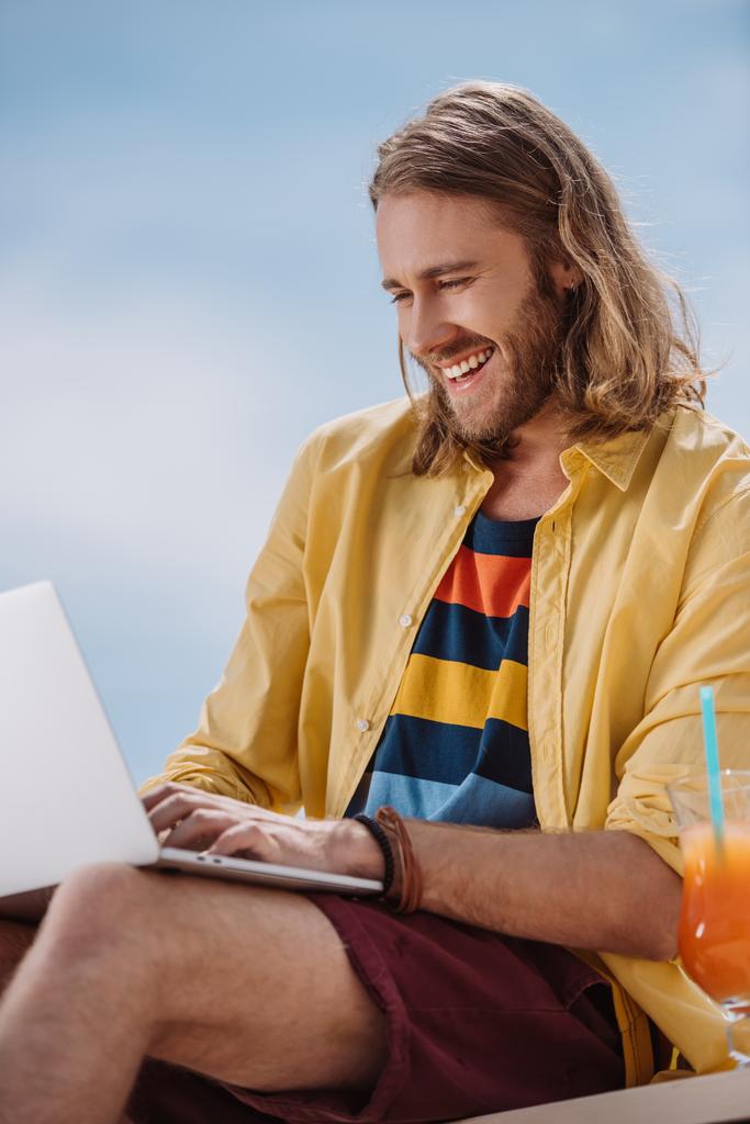 夏の日にノート パソコンを使用して若い男の笑みを浮かべてください。 - 写真・画像