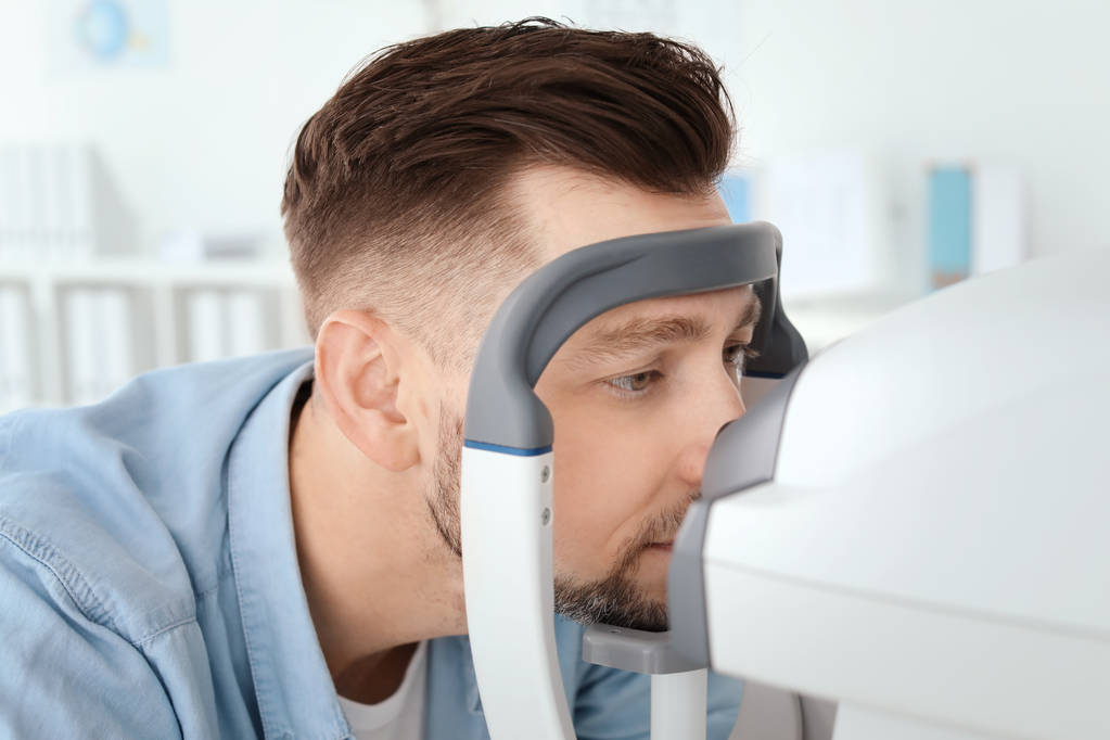 Hombre que visita al oftalmólogo en clínica - Foto, imagen