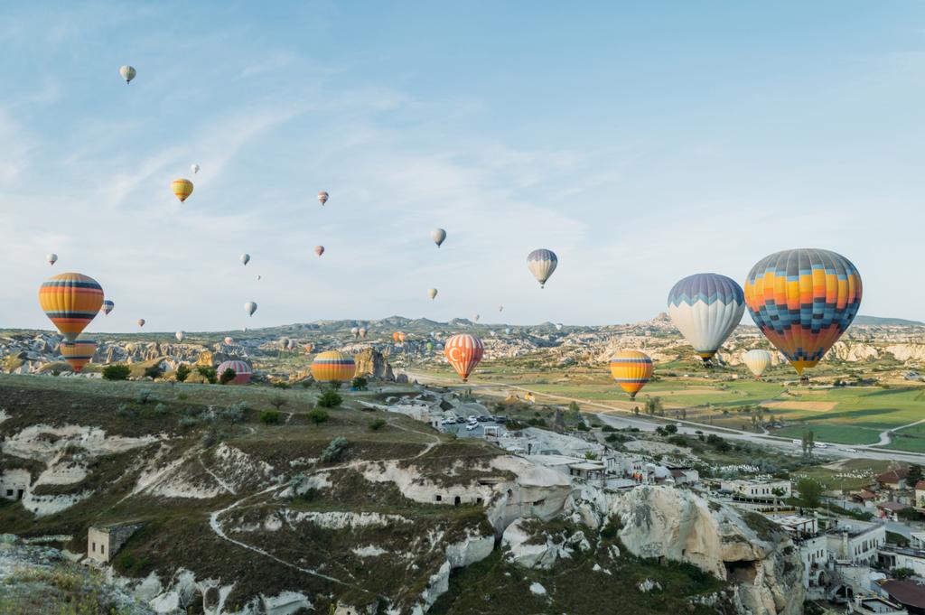 Vooraanzicht van hete lucht ballonnen vliegen over stadsgezicht, Cappadocië, Turkije - Foto, afbeelding