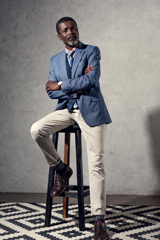 серйозний стильний зрілий афроамериканський чоловік сидить на табуреті
 - Фото, зображення