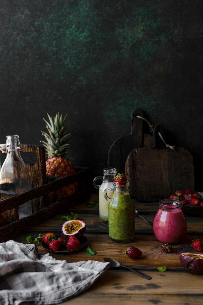 Organik meyve smoothies karmaşa ahşap arka plan üzerinde meyve ile - Fotoğraf, Görsel