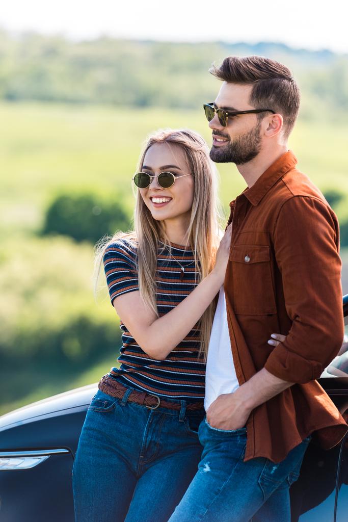 szczęśliwa para stylowe w okulary, stojący w pobliżu samochodu  - Zdjęcie, obraz