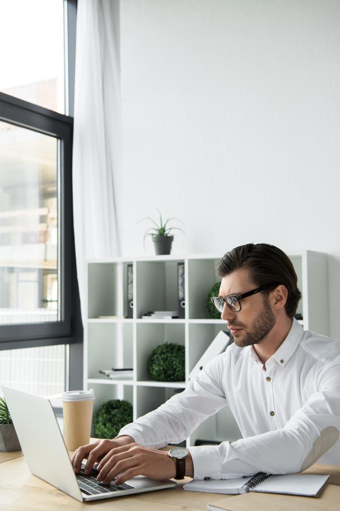 mladý podnikatel pracuje s notebookem v moderní kanceláři zaměřené - Fotografie, Obrázek
