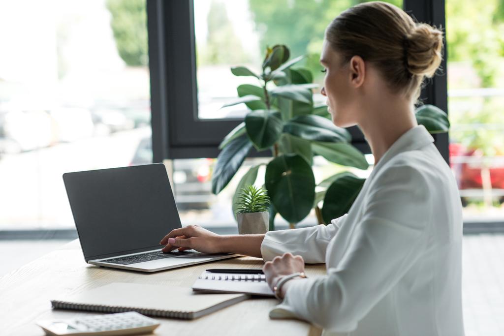 Konzentrierte junge Geschäftsfrau arbeitet mit Laptop im Büro - Foto, Bild