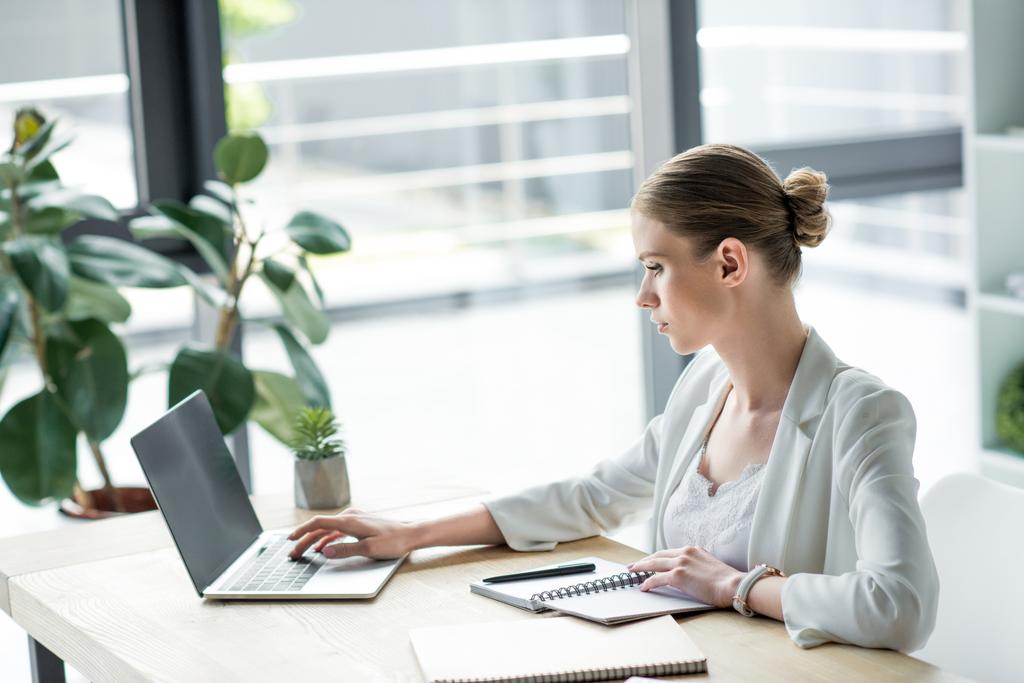 Pewnie kobieta interesu młodych pracę z laptopem w biurze - Zdjęcie, obraz
