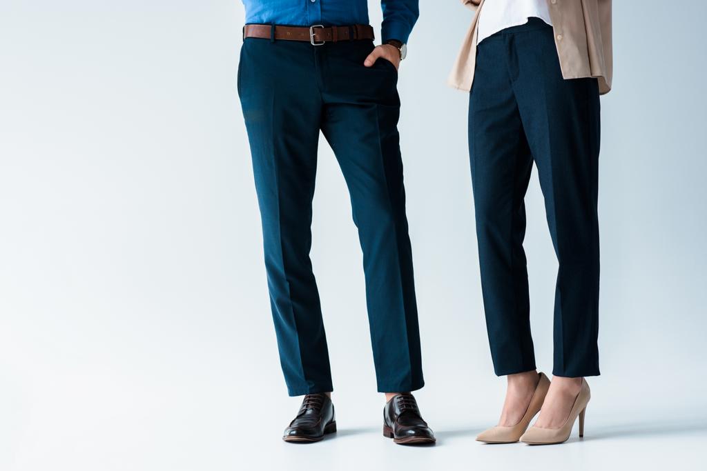обрезанный снимок мужчины и женщины в стильных брюках и обуви на белом
 - Фото, изображение
