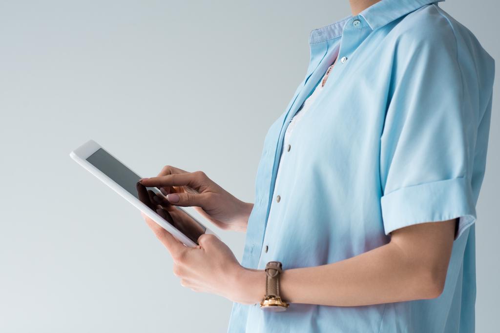 Schnappschuss einer Frau im blauen Hemd mit Tablette isoliert auf grau - Foto, Bild