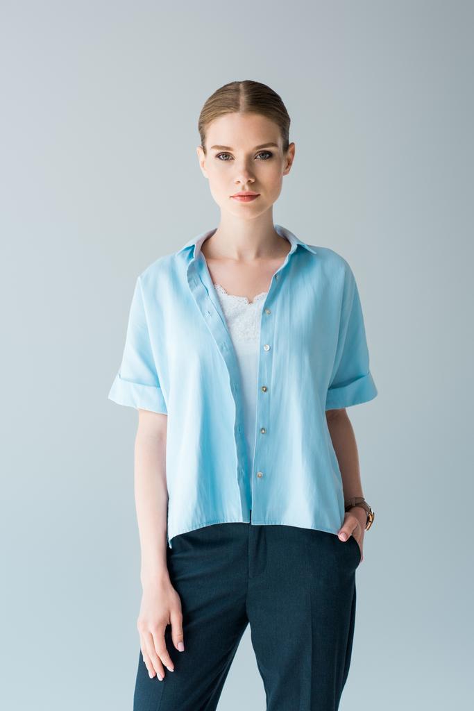 krásná mladá žena ve stylové modré tričko pohledu na cameraisolated Grey - Fotografie, Obrázek
