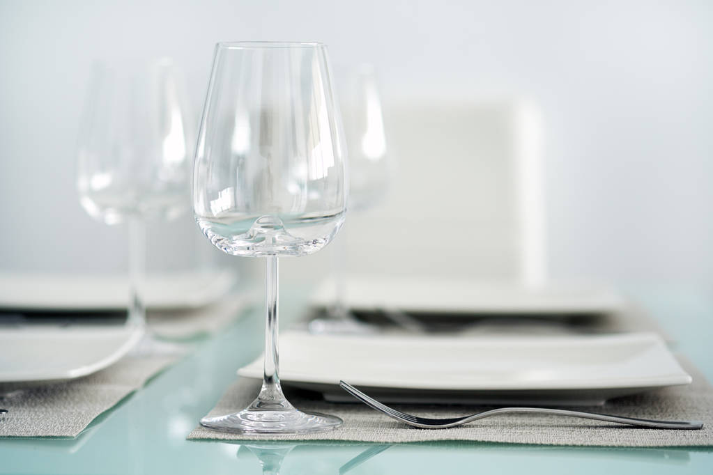 Nakrycie stołu kieliszkami do wina, sztućcami i talerzami - Zdjęcie, obraz