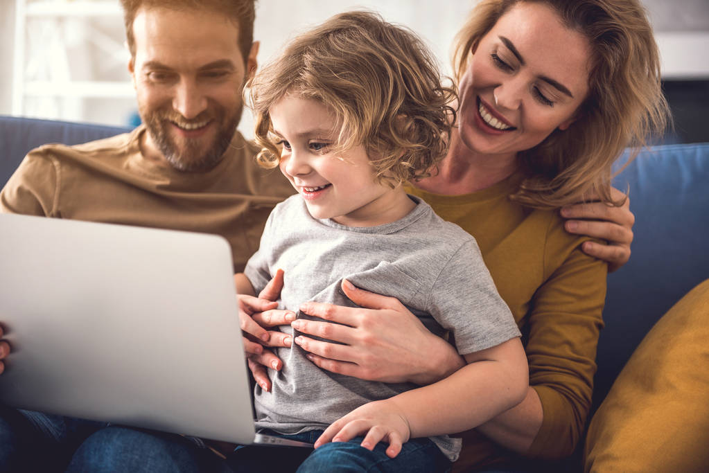 Vrolijke familie bekijkt laptopscherm - Foto, afbeelding