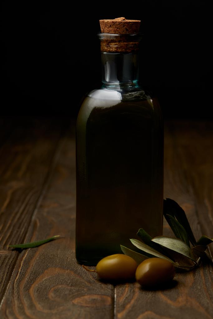 μπουκάλι νόστιμο ελαιόλαδο με υποκατάστημα σε ξύλινη επιφάνεια - Φωτογραφία, εικόνα