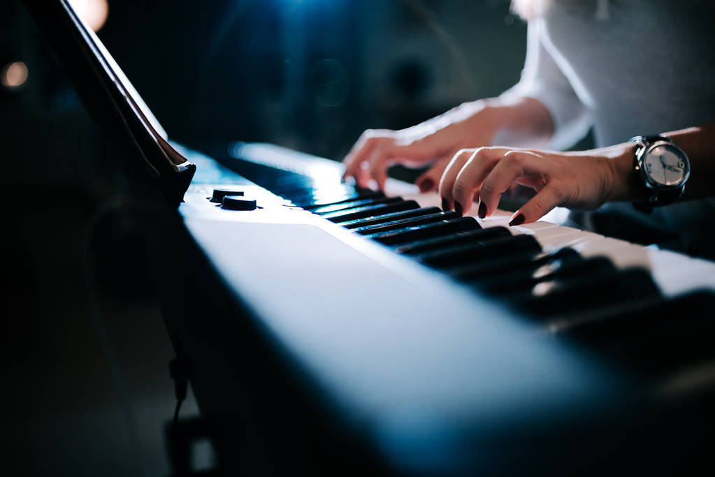 Vista ravvicinata di una mano femminile che suona il sintetizzatore di pianoforte
. - Foto, immagini