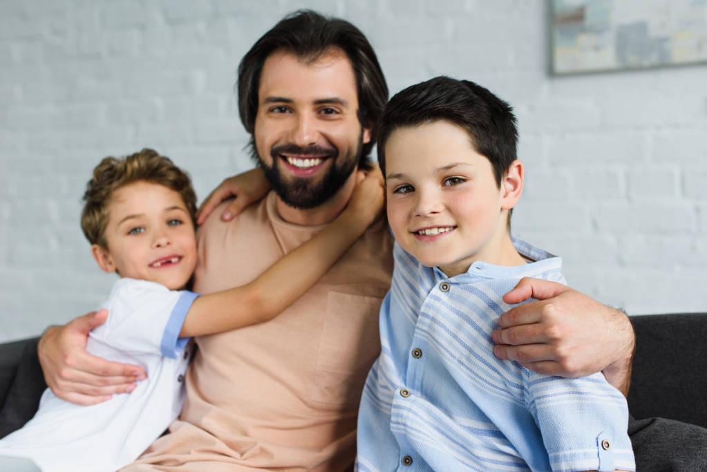 portrait of happy family hugging each other and looking at camera at home - Photo, Image