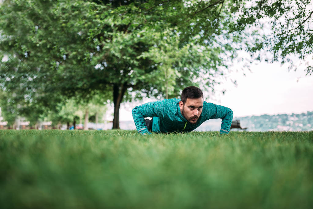 Young man doing push ups in the park. - Photo, Image
