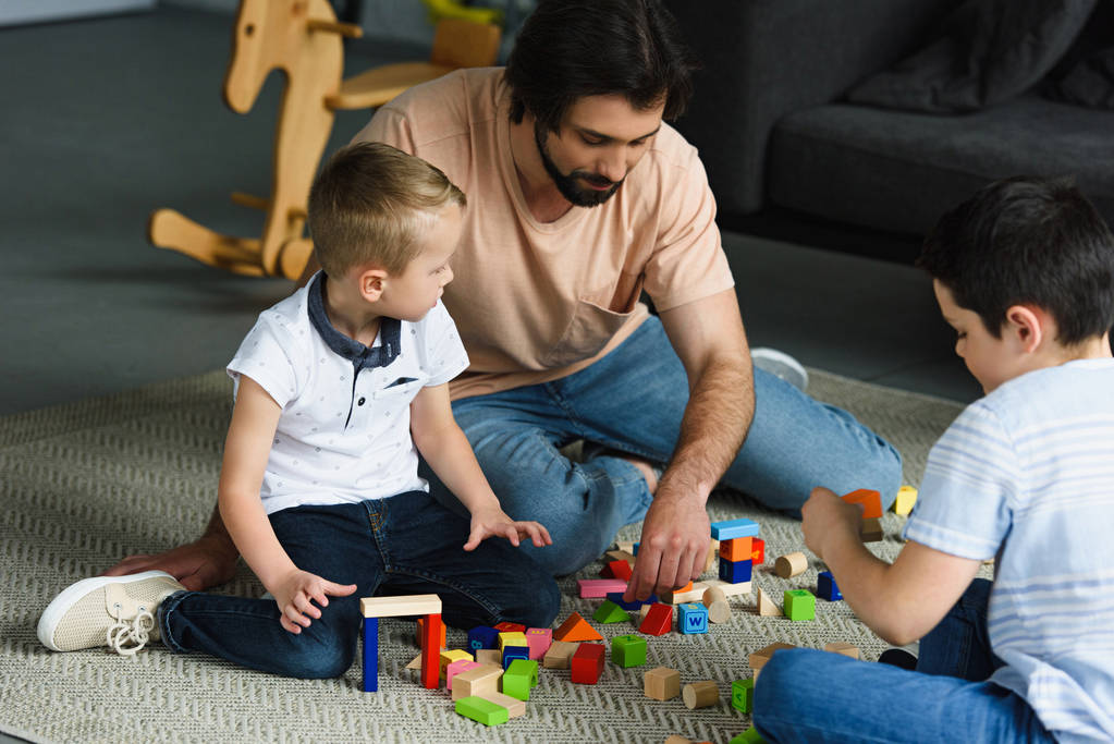 otce a děti hrají s dřevěných bloků na podlahu doma - Fotografie, Obrázek