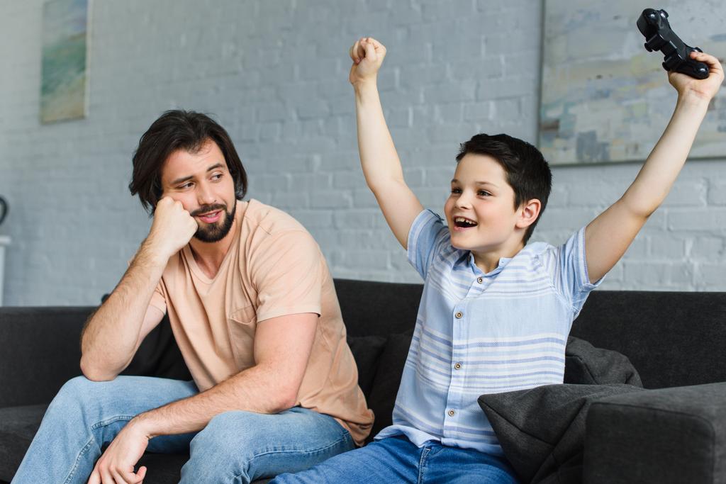 père et fils heureux jouant ensemble à des jeux vidéo à la maison
 - Photo, image
