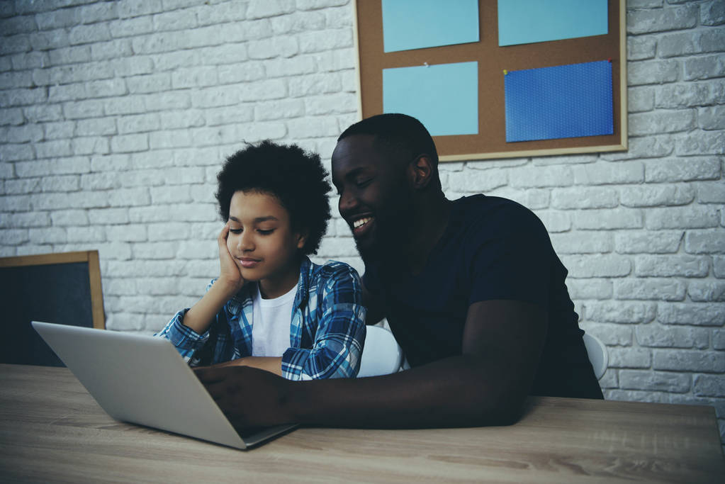 Афроамериканский отец и сын просматривают веб
 - Фото, изображение