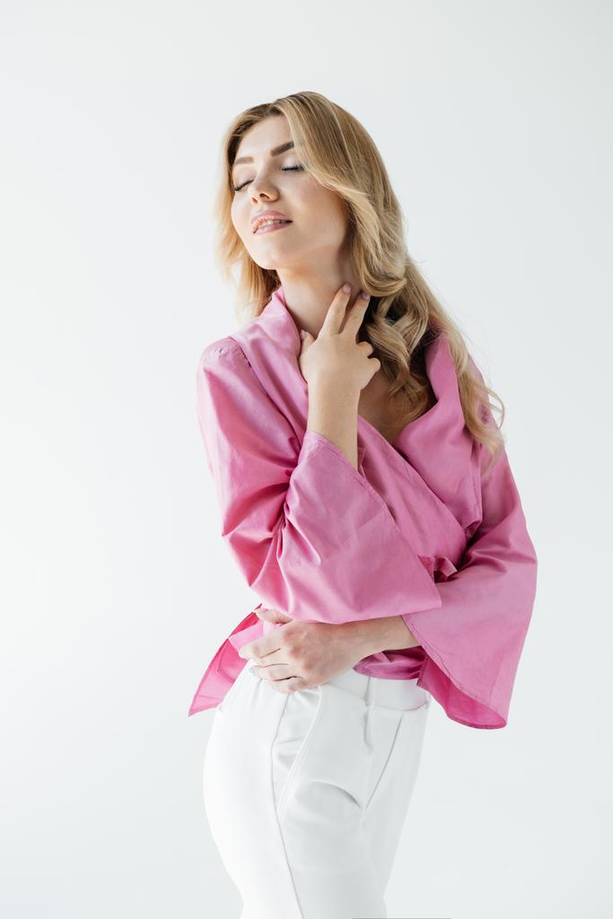 πορτρέτο του ελκυστική νεαρή γυναίκα σε ροζ μπλούζα θέτοντας απομονωθεί σε λευκό - Φωτογραφία, εικόνα