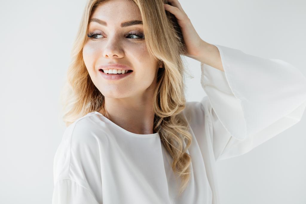 portrait of beautiful smiling woman in white clothing looking away on white backdrop - Photo, Image