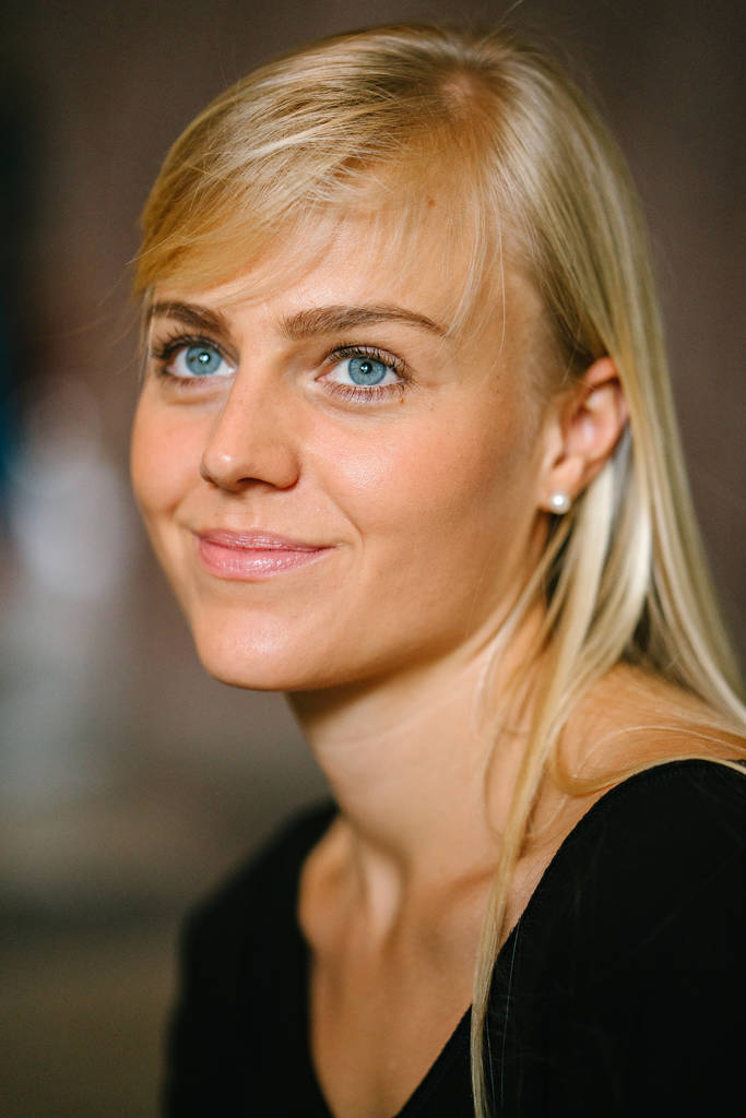 Close-up hoofd geschoten van een jonge, aantrekkelijke blonde vrouw met blauwe ogen. Ze lacht  - Foto, afbeelding