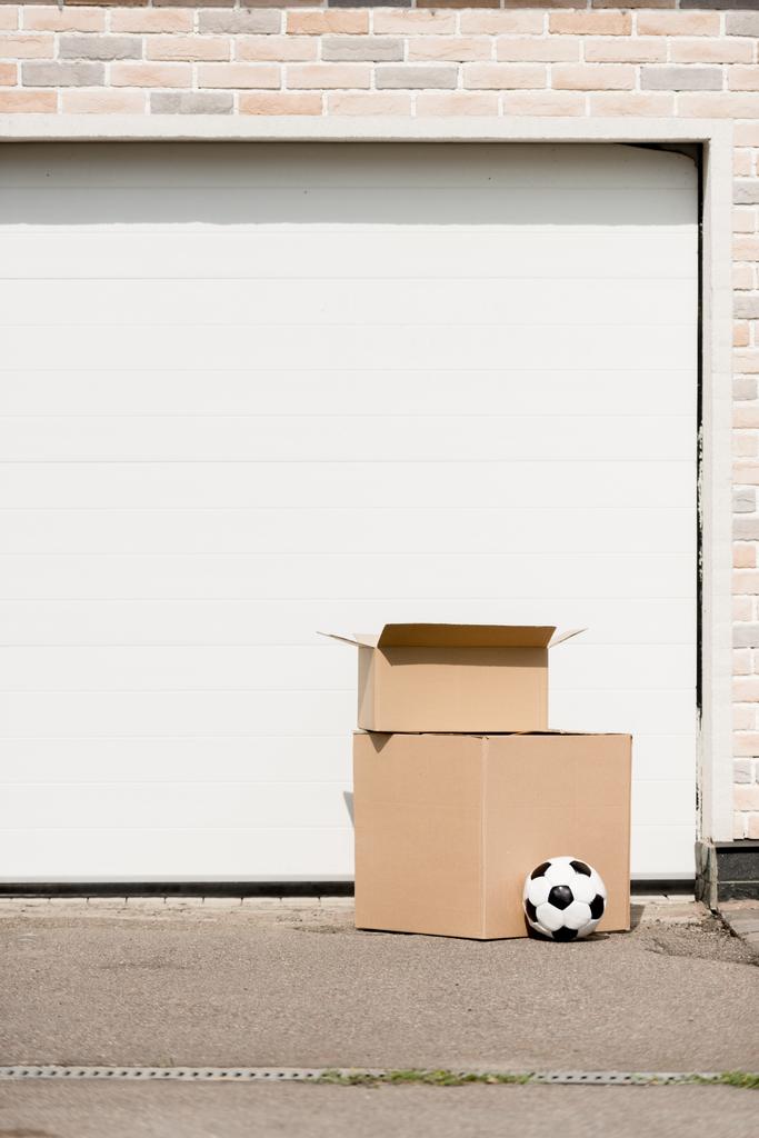 close up view of boxes, soccer ball in front of garage gate - Photo, Image