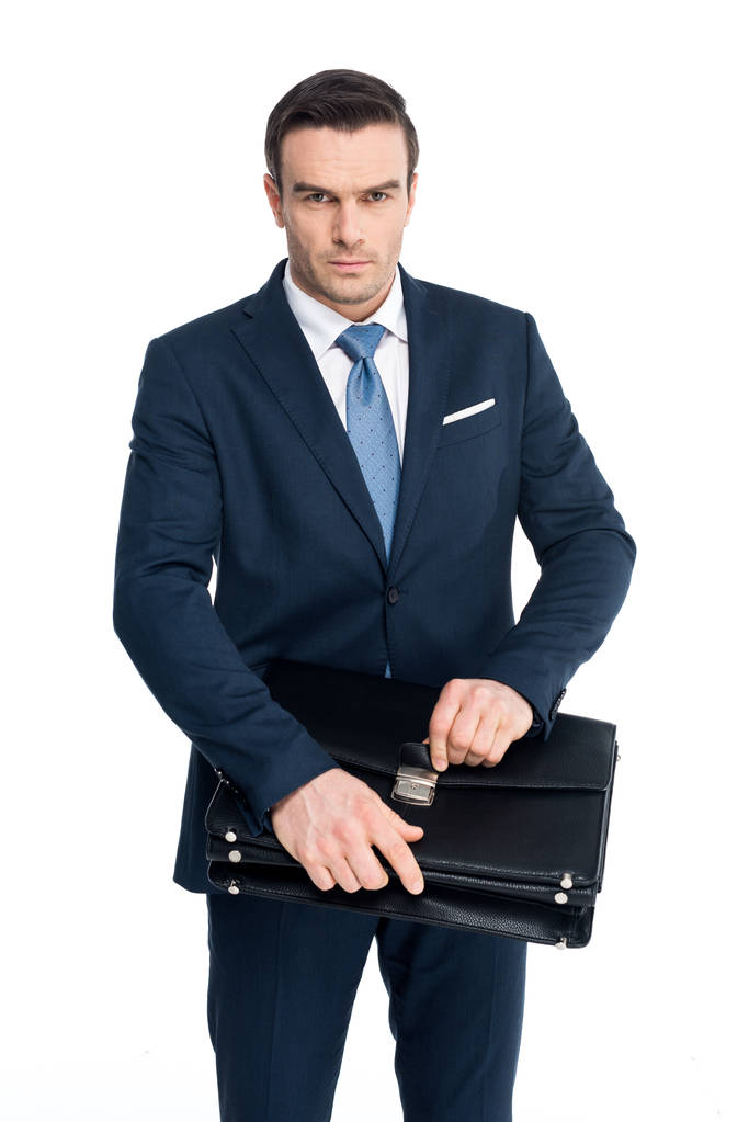 серйозний бізнесмен середнього віку тримає портфель і дивиться на камеру ізольовано на білому
 - Фото, зображення