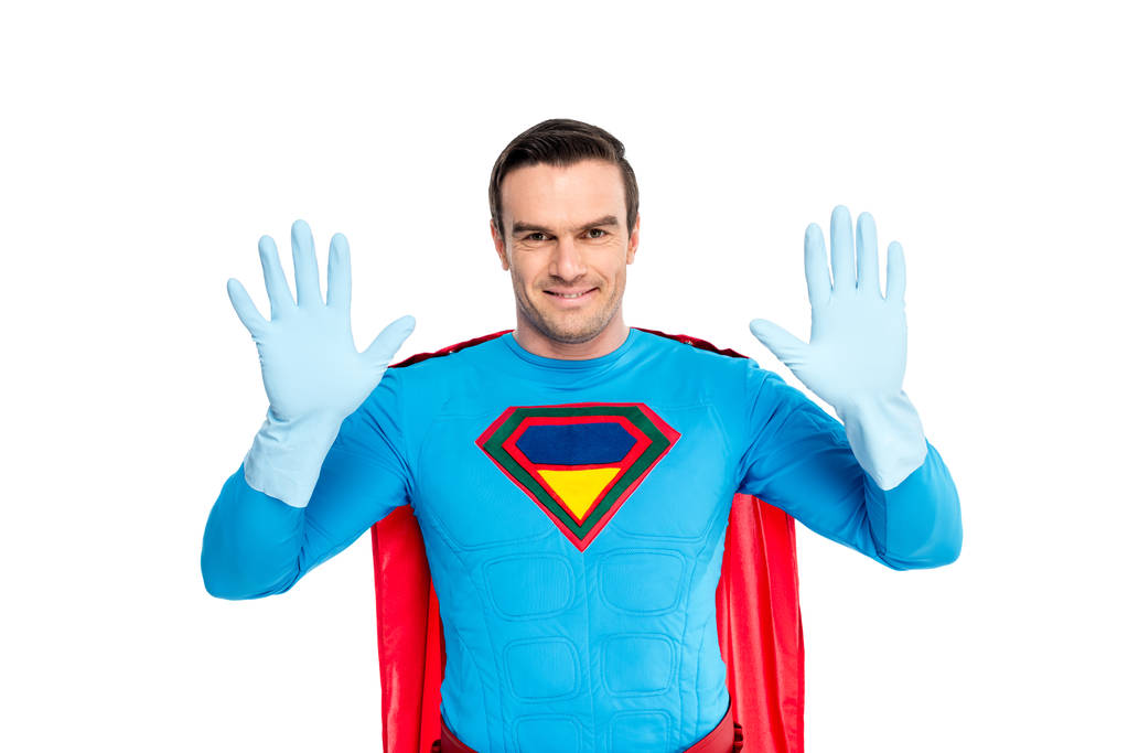 guapo superhéroe mostrando las manos en guantes de goma y sonriendo a la cámara aislada en blanco
 - Foto, Imagen