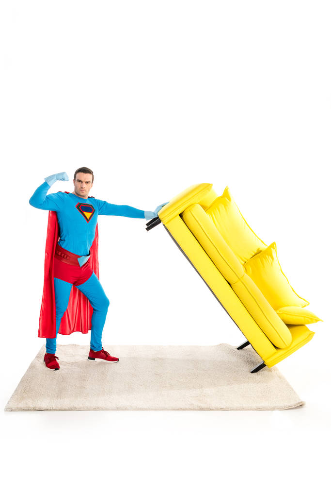 superhero gospodarstwa kanapie i Wyświetlono biceps na białym tle - Zdjęcie, obraz