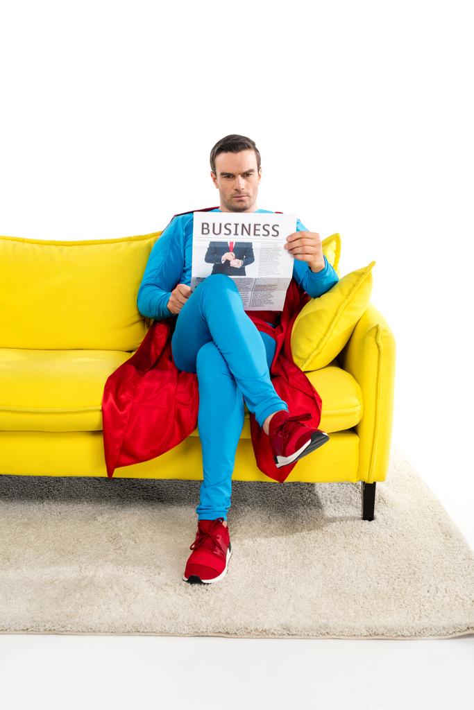 täyspitkä näkymä vakava mies supersankari istuu sohvalla ja lukeminen liiketoiminnan sanomalehti eristetty valkoinen
  - Valokuva, kuva
