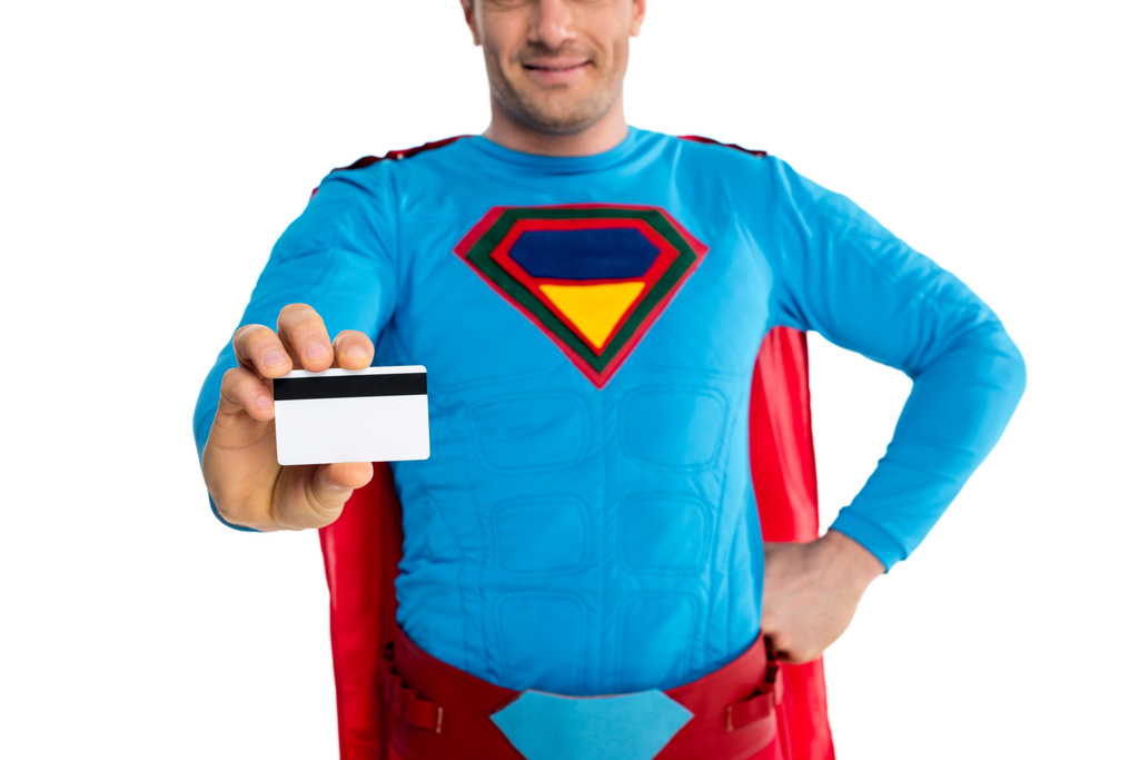 cropped shot of smiling male superhero holding credit card isolated on white - Photo, Image
