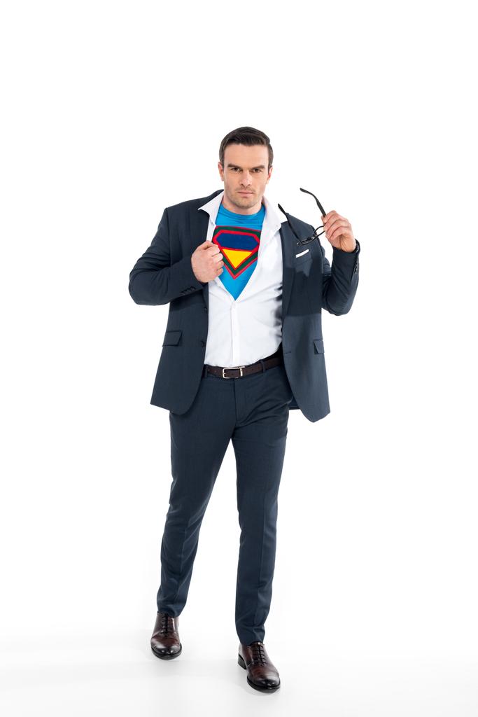 αυτοπεποίθηση επιχειρηματία στο κοστούμι superhero υπό κοστούμι απογειώνεται γυαλιά και βλέπουν τα φωτογραφικών μηχανών που απομονώνονται σε λευκό - Φωτογραφία, εικόνα
