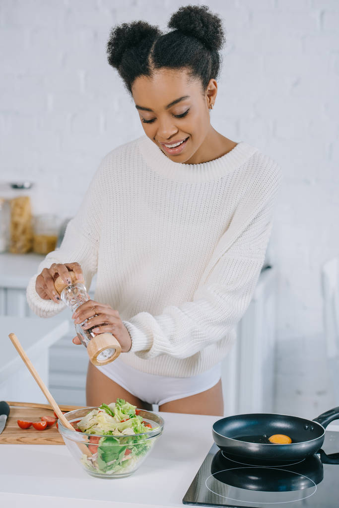 kaunis nuori nainen pippuri mill pippuri salaatti keittiössä
 - Valokuva, kuva