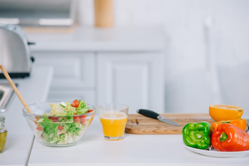 Gros plan de la salade fraîche et du jus d'orange sur la table de la cuisine
 - Photo, image