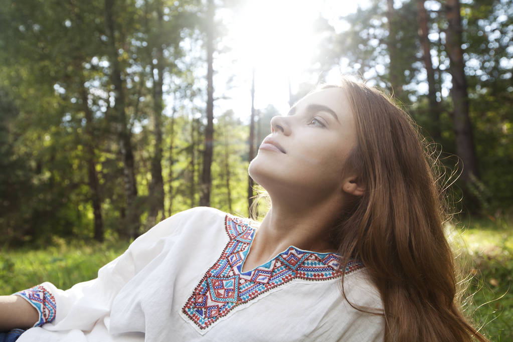 Relaksujący młoda kobieta na leśnej polanie. Tle natura. - Zdjęcie, obraz
