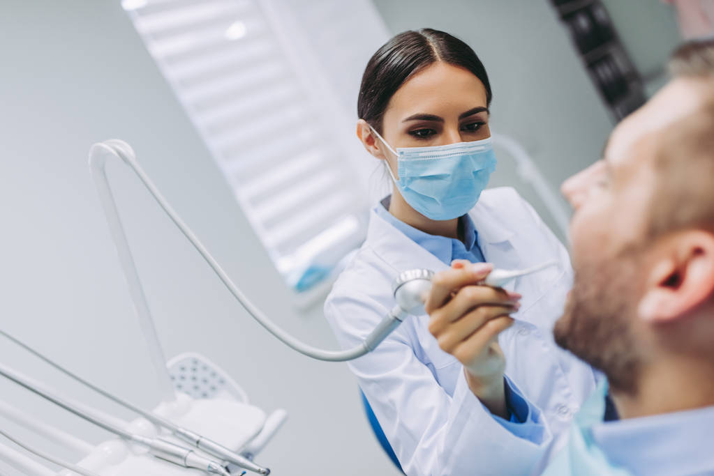 muotokuva hammaslääkäri hoitaa potilaan hampaat moderni hammashoitola
 - Valokuva, kuva