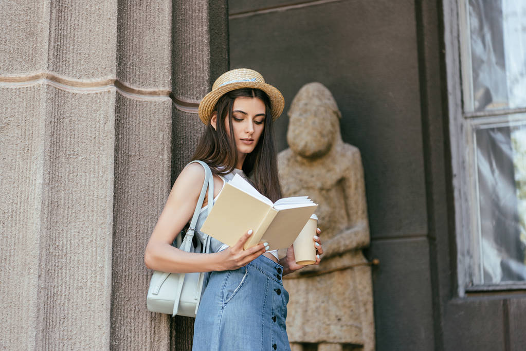 krásná dívka v klobouku pohárek a čtení knih u sloupce - Fotografie, Obrázek