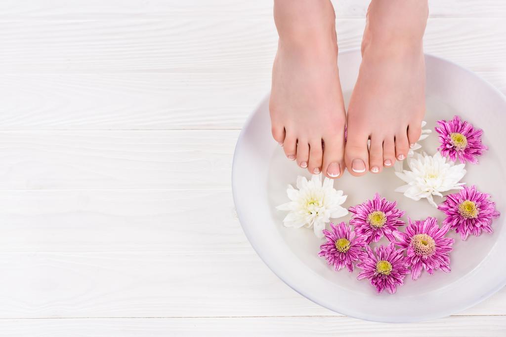 osittainen näkymä paljain jaloin nainen vastaanottaa kylpy kynnet kukkia kauneushoitola
 - Valokuva, kuva