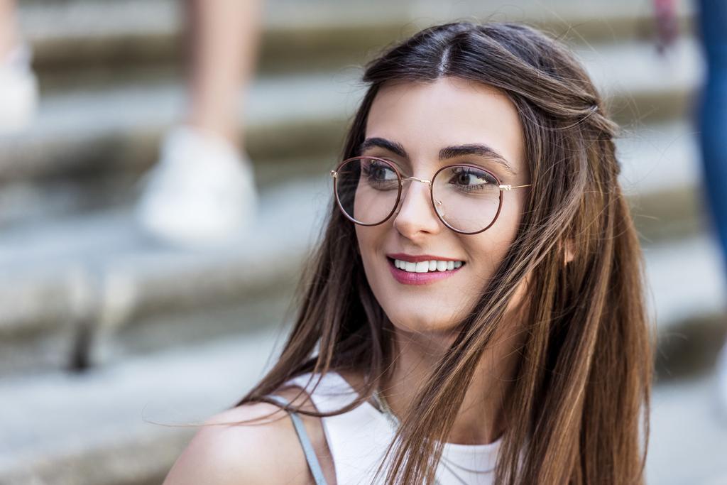 portrait of attractive smiling woman in eyeglasses on street - Photo, Image