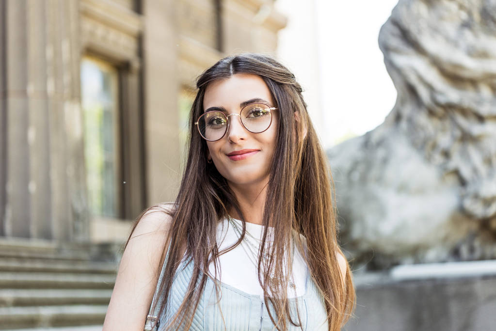 portrait of attractive smiling woman in eyeglasses on street - Photo, Image