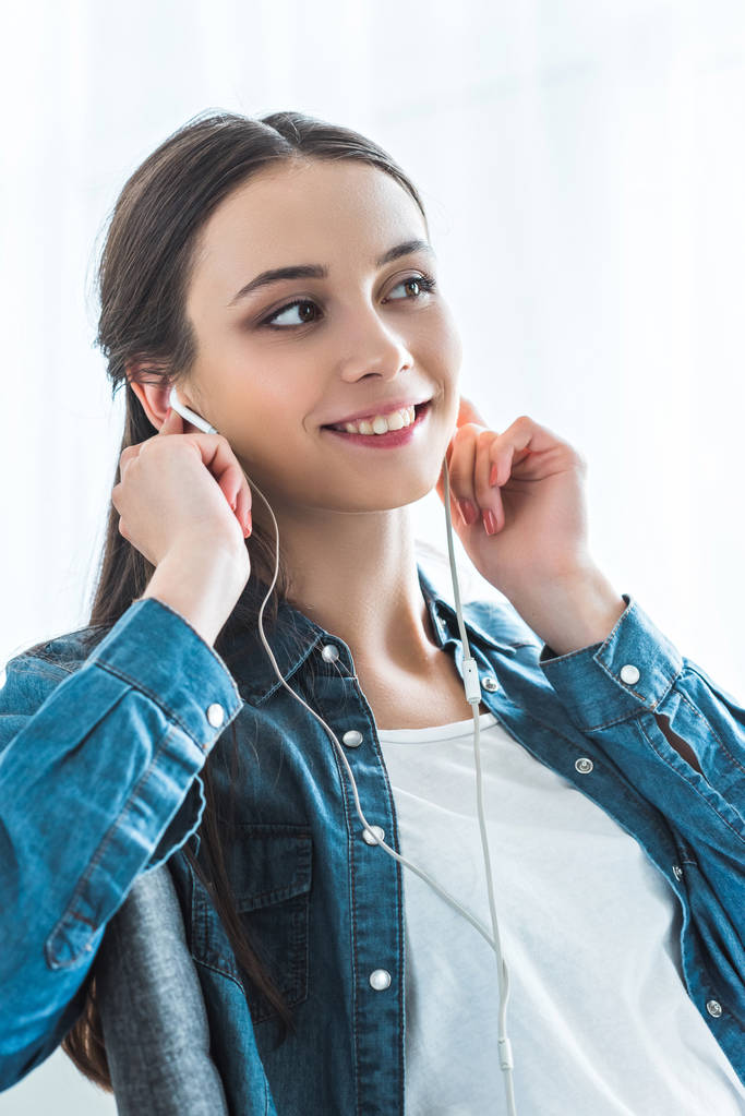 piękny uśmiechający się nastolatkę słuchania muzyki w słuchawkach i szukasz drogi - Zdjęcie, obraz